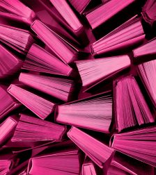 Book background in Viva Magenta colors. Red books top view. Color of the year 2023