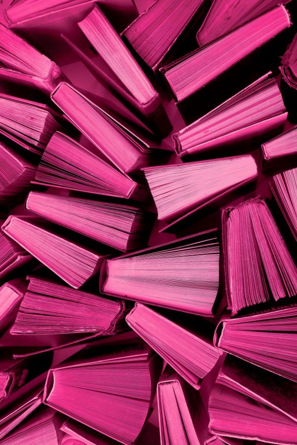 Book background in Viva Magenta colors. Red books top view. Color of the year 2023